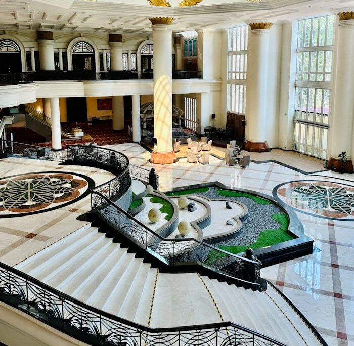 The lobby of a hotel with a large marble staircase